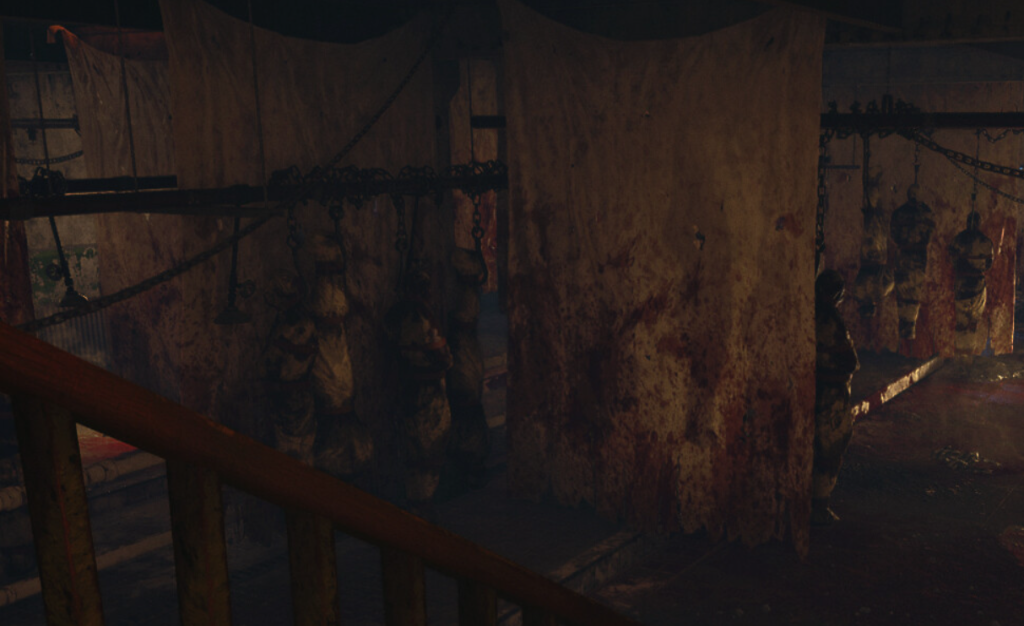 A dim room with bloodstained sheets, hanging bodies and chains.